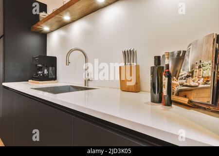 Frigorifero moderno con comoda presa per bevande, situato nella cucina moderna e luminosa di casa Foto Stock