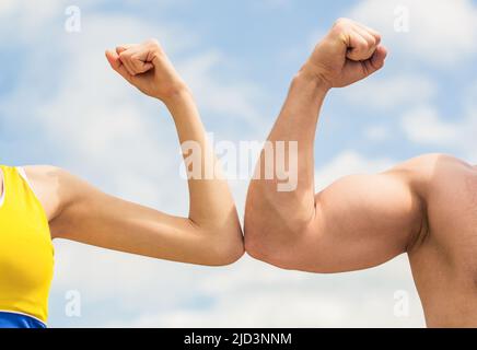 Concetto di rivalità. Mano, uomo braccio pugno primo piano. Rivalità, vs, sfida, confronto di forza. Uomo e donna sportivi. Braccio muscolare vs mano debole. Contro, lotta Foto Stock