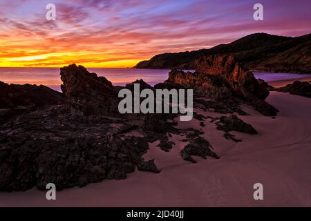 Dark Scenic Seascape alba a bassa marea sulla spiaggia di Burgess nella città costiera di Forster in Australia. Foto Stock