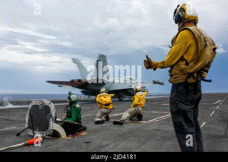 I marinai FILIPPINI (15 giugno 2022) dirigono il lancio di un EA-18G Growler, assegnato ai 'Wizards' di Electronic Attack Squadron (VAQ) 133, sul ponte di volo della portaerei di classe Nimitz USS Abraham Lincoln (CVN 72). Abraham Lincoln Strike Group è in fase di implementazione pianificata nell'area delle operazioni della flotta USA 7th per migliorare l'interoperabilità attraverso alleanze e partnership, fungendo da forza di risposta pronta a supportare una regione indopacifica libera e aperta. (STATI UNITI Foto Navy di Mass Communication Specialist 3rd Classe Michael Singley) Foto Stock