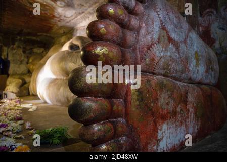 Piedi giganti di scultura antica di Buddha reclinato nel tempio della grotta buddista di Rangiri Dambulu Raja Maha Viharaya (Tempio dorato). Dambulla, Sri Lanka Foto Stock