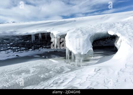 Ingresso a una grotta di ghiaccio sotto Breiðamerkurjökull. Un ghiacciaio di uscita del più grande ghiacciaio Vatnajökull che si estende in una piccola laguna con ghiaccio cav Foto Stock