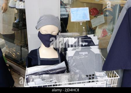 Abbigliamento per i lavoratori del ristorante esposto all'esterno di un negozio specializzato di abbigliamento per ristoranti nell'area di Kappabashi a Tokyo. Foto Stock