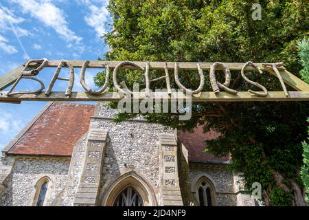 St Stephen's Church e insolito segno nel villaggio di Baughurst, Hampshire, Inghilterra, Regno Unito Foto Stock