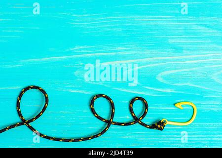 Braccialetto nero e giallo a gancio di pesce su sfondo blu in legno con spazio copia. Foto Stock
