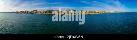 Panorama sul lungomare con persone che camminano vicino profondo calma fresco Mar Nero, sullo sfondo di antica località cittadina di Pomorie in Bulgaria unde Foto Stock