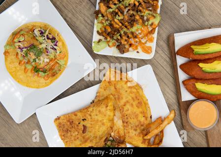 Vista dall'alto di appetitose scelte di patatine quesadilla, taco o asada patatine fritte per un'allettante gastronomia messicana. Foto Stock