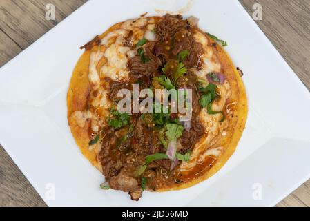 Vista dall'alto dell'appetitoso birria taco con tutti i condimenti per un'allettante gastronomia messicana. Foto Stock