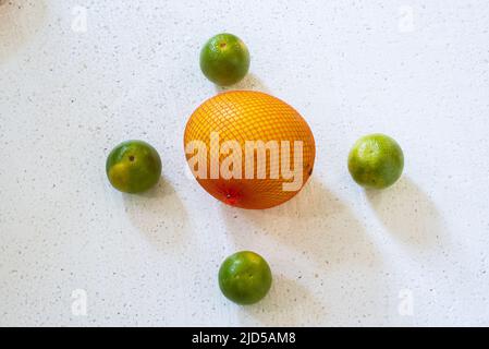 Quattro arance e un melone giallo al centro su sfondo bianco. Salvador, Bahia, Brasile. Foto Stock