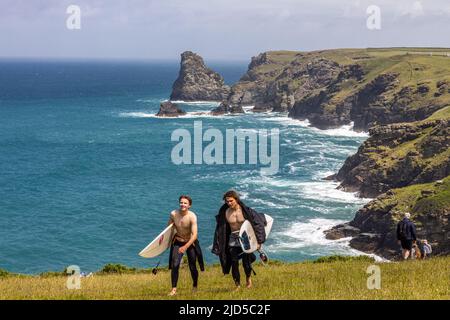 Due giovani dudi surf con tavole sembrano felici dopo una giornata in sella alle onde della costa impressionante vicino a Tintagel Cornwall Inghilterra Regno Unito Foto Stock