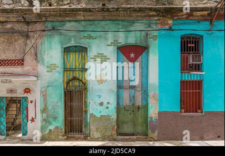 Facciata colorata casa con bandiera cubana dipinta a Old Havana, Cuba Foto Stock