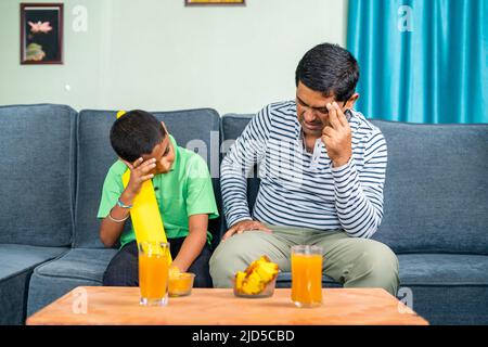 Padre e figlio si sono arrabbiato mentre guardavano la partita di cricket dal vivo a casa a causa della perdita della partita o del wicket - concetto di intrattenimento, appassionati di sport e infelici Foto Stock