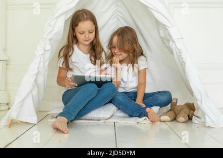 Felici i bambini che usano un tablet nel soggiorno di casa Foto Stock