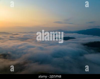 Alba sul mare di nuvole e vette di montagna Foto Stock