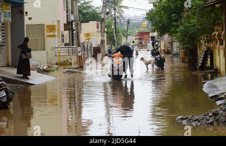 Bangalore, India. 18th giugno 2022. La gente cammina su una strada loggata ad acqua a Bangalore, India, 18 giugno 2022. Credit: Str/Xinhua/Alamy Live News Foto Stock