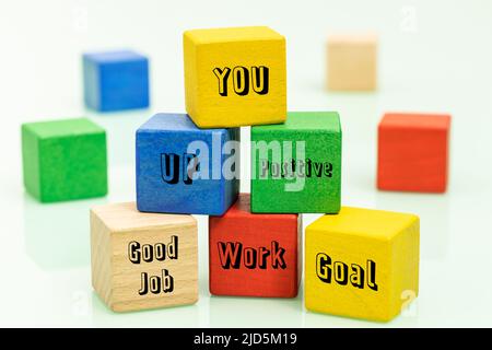 Blocchi di legno colorati con parole motivanti che incoraggiano lo sviluppo di sé, il concetto di costruire un modello di business positivo che supporta il proprio de Foto Stock