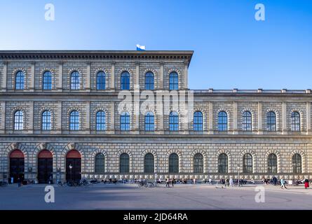 Patroni dell'opera seduti all'intervallo sulla porta accanto Munich Residenz (residenza), ex palazzo reale dei monarchi di Wittelsbach della Baviera. Foto Stock
