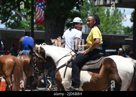 Zebulon, NC, USA, 18th giugno 2022, i cowboys afroamericani sfilano a cavallo attraverso il centro di Zebulon come parte di un fine settimana lungo Giunetteesimo celebrazione di emancipazione dalla schiavitù. A partire dal 2021, Giunetseicento è una festa federale che commemora l'annuncio militare del giugno 19 1865 che annuncia la libertà per le persone schiavate a Galveston, Texas. Molti schiavi in Texas non erano a conoscenza della proclamazione di emancipazione del presidente Lincoln del 1863 che li liberava dalla schiavitù due anni prima e gli schiavi a Galveston erano gli ultimi ad ascoltare la notizia. Credit D Guest Smith / Alamy Live News Foto Stock