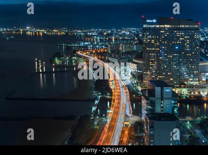 kyushu, fukuoka - dicembre 06 2021: Vista notturna a volo d'uccello della città di Fukuoka con il percorso circolare illuminato della superstrada urbana lungo la costa Foto Stock