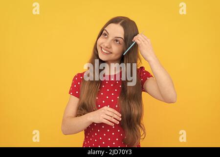 ritratto di bambino frizz. cura dei capelli e perdita dei capelli. modella moda femminile. bambino sorridente pettinare i capelli. Foto Stock