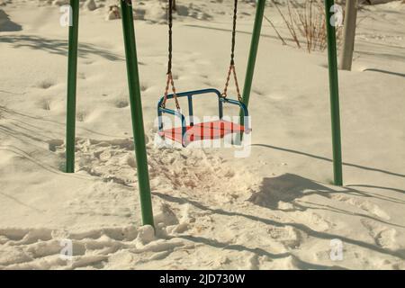 Swing in inverno. Parco giochi per bambini nella neve. Altalene su corde. Luogo di riposo per i bambini. Foto Stock