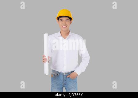 Ritratto giovane asiatico uomo è ingegnere indossare casco in piedi e tenendo piano con sicuro isolato su sfondo bianco, bello maschio è archi Foto Stock