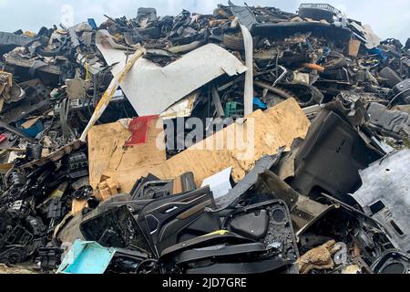 Accatastato su macchine compresse che vanno sminuzzate, deposito della spazzatura, molti vecchi veicoli danneggiati sulla discarica dell'automobile Foto Stock