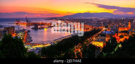Vista aerea della città di Malaga al tramonto con colori caldi e luci della città. Foto Stock