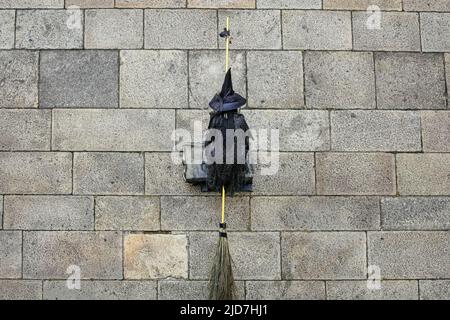 Donna travestita come una strega sul pavimento di granito della città. Foto Stock