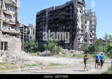 Mariupol. 18th giugno 2022. I residenti passeggiando accanto edifici danneggiati a Mariupol 18 giugno 2022. Credit: Victor/Xinhua/Alamy Live News Foto Stock