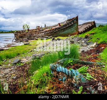 Salen, Isola di Mull, Scozia - Derelict barche da pesca in legno abbandonate sulla spiaggia che sta lentamente decadendo e marciando Foto Stock