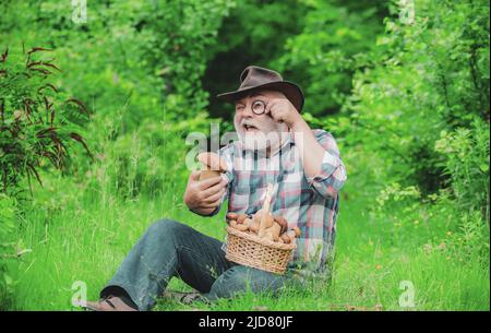 Buon nonno - estate e hobby. Vecchio che cammina. Nonno pensionato. Trekking senior nella foresta. Nonno con cestino di funghi e un Foto Stock