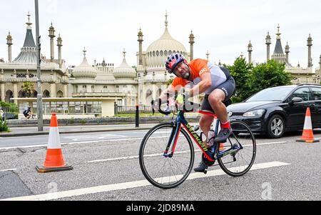 Brighton UK 19th Giugno 2022 - Una testa di ciclista passa il Royal Pavilion di Brighton dopo aver partecipato alla corsa in bicicletta da Londra a Brighton in aiuto della British Heart Foundation in una giornata molto più fredda di quanto non sia stata recentemente : Credit Simon Dack / Alamy Live News Foto Stock