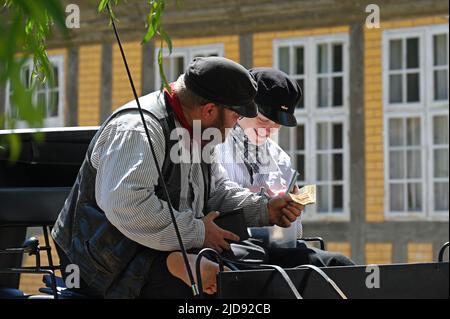 Due coachmen sono felici di una banconota che hanno preso Foto Stock