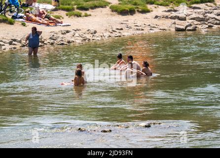 Monaco di Baviera, Germania. 19th giugno 2022. I bagnanti si raffreddano presso e nel fiume Isar, che scorre attraverso il centro della capitale bavarese. Credit: Peter Kneffel/dpa/Alamy Live News Foto Stock