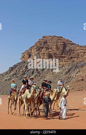 Turisti in giro per i cammelli a Wadi Rum, Giordania Foto Stock