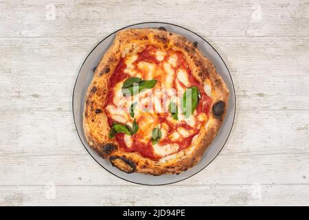 Pizza italiana fatta a mano fresca su tavolo in legno con vista ad angolo alto Foto Stock