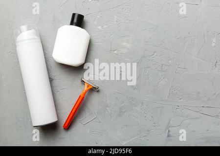 set uomo per la rasatura. macchina per la rasatura, asciugamano, lozione e schiuma per la rasatura su sfondo colorato. Accessori bagno uomo vista dall'alto. Foto Stock