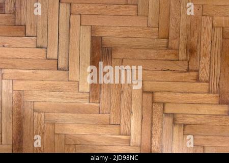 Parquet in legno naturale a spina di pesce. Pavimenti in legno di quercia. Vecchio asse decorativo marrone, motivo ripetuto. Interno della casa, vista dall'alto Foto Stock