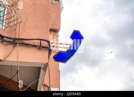 Negozio di farmacia segno sotto forma di una mano telefonica sul muro, con fili elettrici. Distretto Bourgogne di Casablanca, Marocco Foto Stock