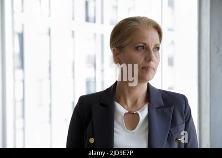 Head shot ritratto di mezza età businesswoman posa in ufficio moderno Foto Stock