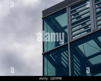 Edificio dall'architettura moderna con grandi finestre di vetro. Esterno di un edificio contemporaneo con elementi in acciaio sulla facciata. Nuova casa da ufficio vuota. Foto Stock