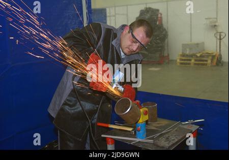 Saldatrice rettifica lamiera con smerigliatrice, preparazione saldatura, officina. 17 novembre 2021 Kiev Ucraina Foto Stock