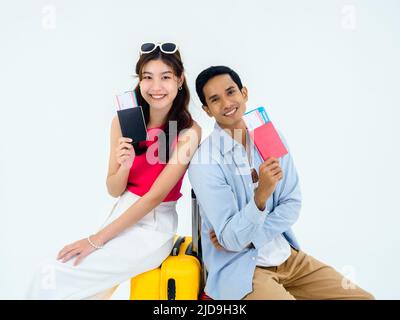 Pronto a viaggiare, buona vacanza. Concetto di vacanza estiva. Sorridente coppia asiatica che tiene passaporti e biglietti di volo, guardando macchina fotografica, giovane donna e ma Foto Stock