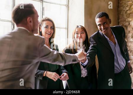 Un gruppo di giovani imprenditori multietnici che si scuotono le mani durante un concetto di business-lifestyle aziendale, accordo commerciale internazionale Foto Stock