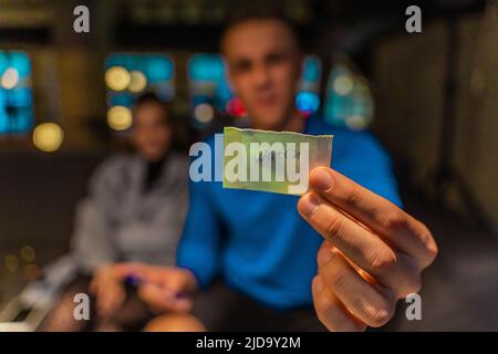 Gli amici stanno scrivendo le parole sulla carta per il gioco di indovinare Foto Stock