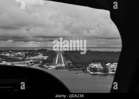 Un colpo bianco e nero della pista all'aeroporto Caye Caulker come visto dal cockpit in una giornata nuvolosa. Foto Stock