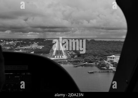 Un colpo bianco e nero della pista all'aeroporto Caye Caulker come visto dal cockpit in una giornata nuvolosa. Foto Stock