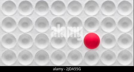 Un uovo rosso in un fumetto bianco vuoto. ( Fuoco selettivo ) concetto di differenza e solitudine. Foto Stock