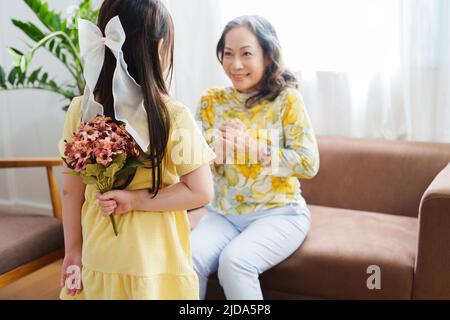 Ritratto asiatico, nonna e nipote che fanno attività di svago e abbraccia per mostrare il loro amore e la cura per gli altri Foto Stock